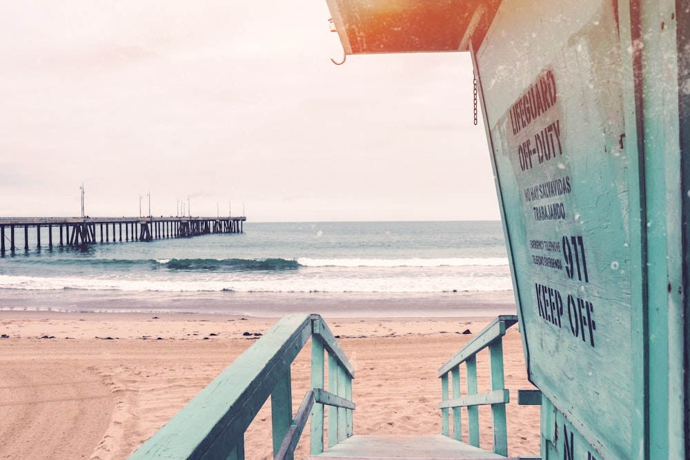 teal wooden lifeguard shed near seashore