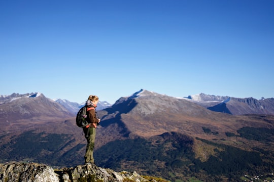 woman standing on cliff in Melshornet Norway