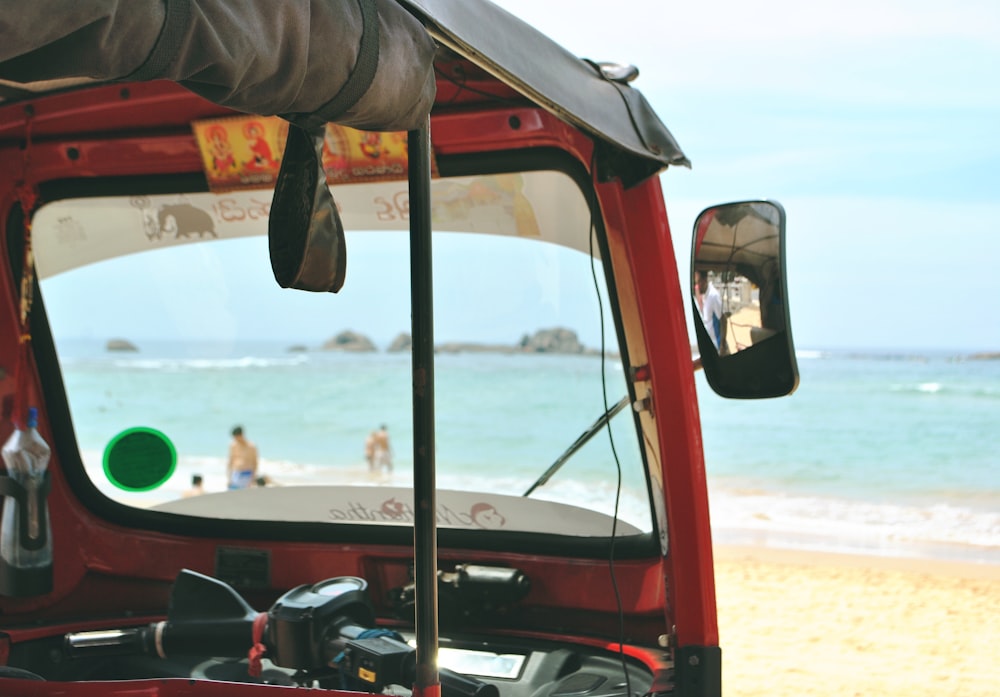 Foto de auto-rickshaw rojo frente al mar