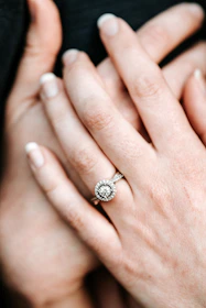 A jeweler’s hands carefully setting a sparkling diamond into a sleek gold band.