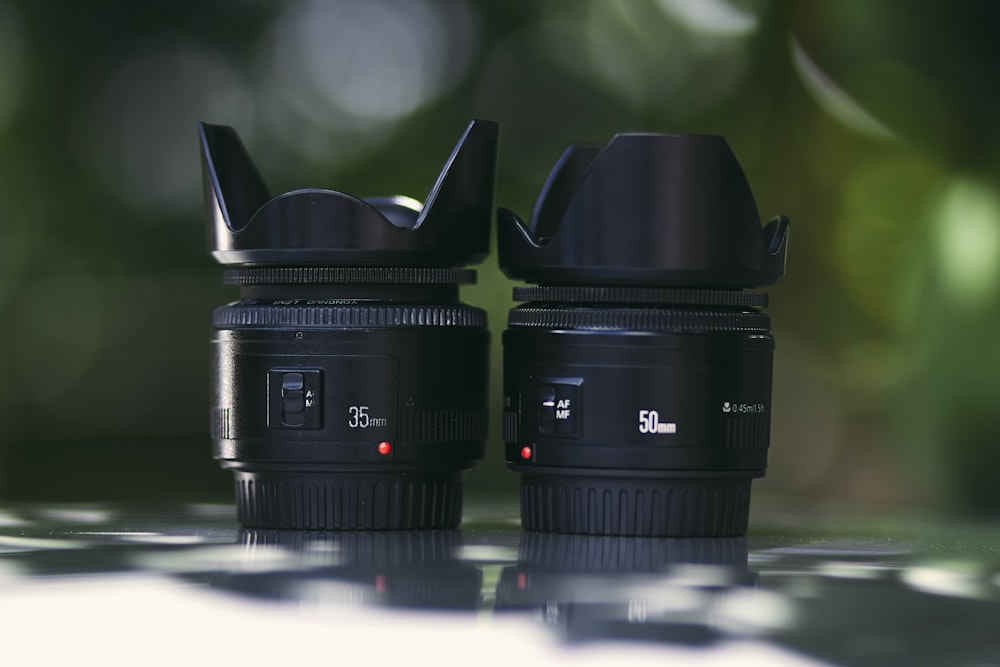 shallow focus photography of two black zoom lens