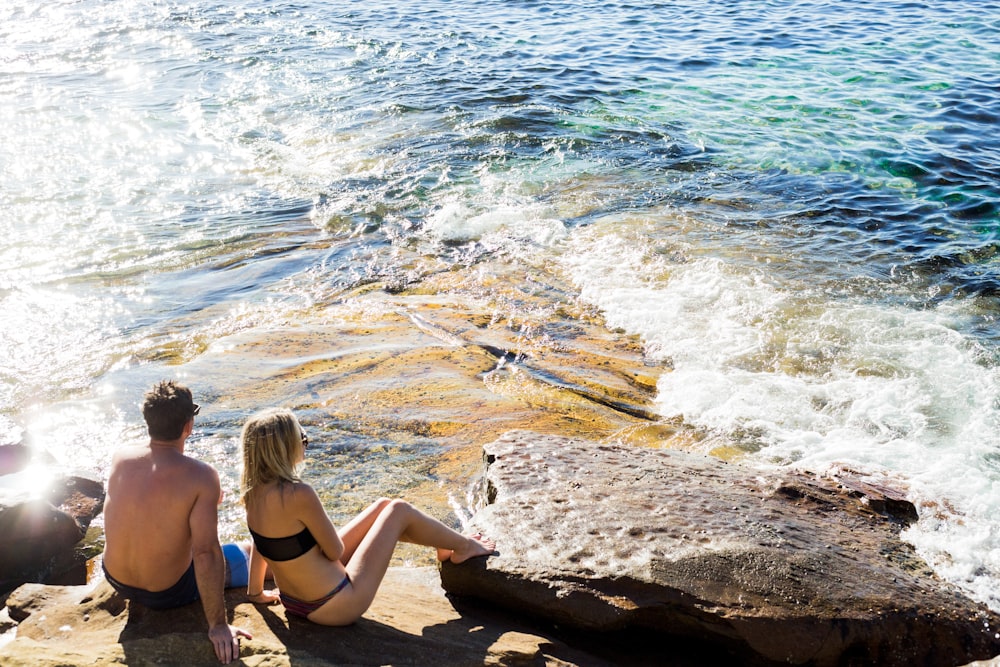 man and woman sitting next to each other in beach