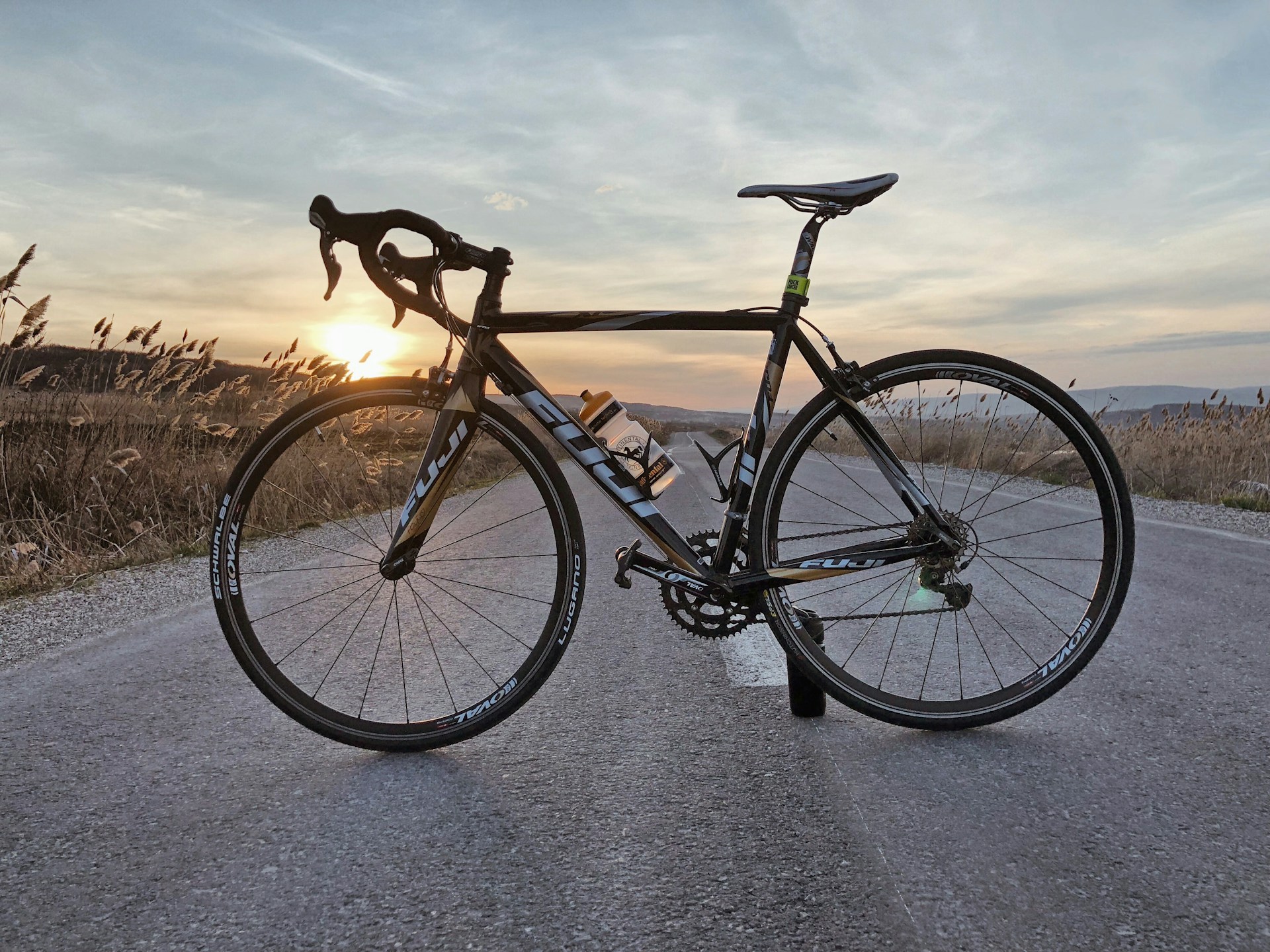 golden hour photography of racing bicycle in middle of road