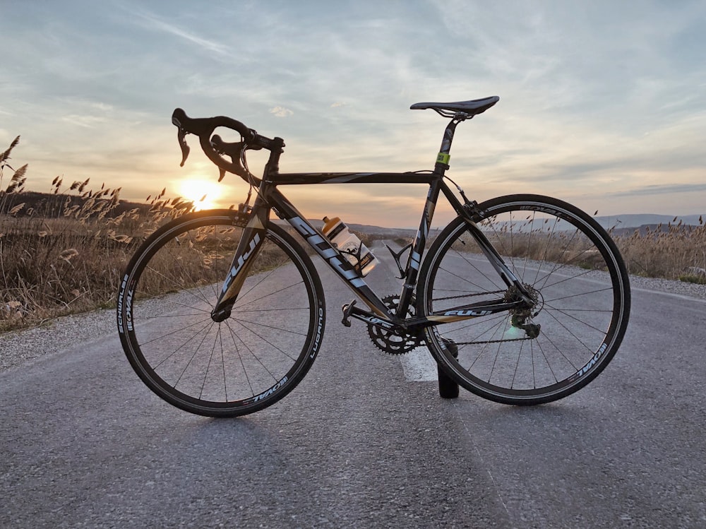 golden hour photography of racing bicycle in middle of road