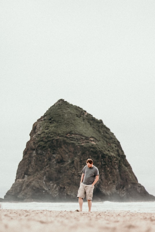 man standing on beach in Haystack Rock United States