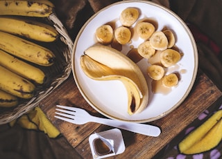sliced ripe banana on round white ceramic plate