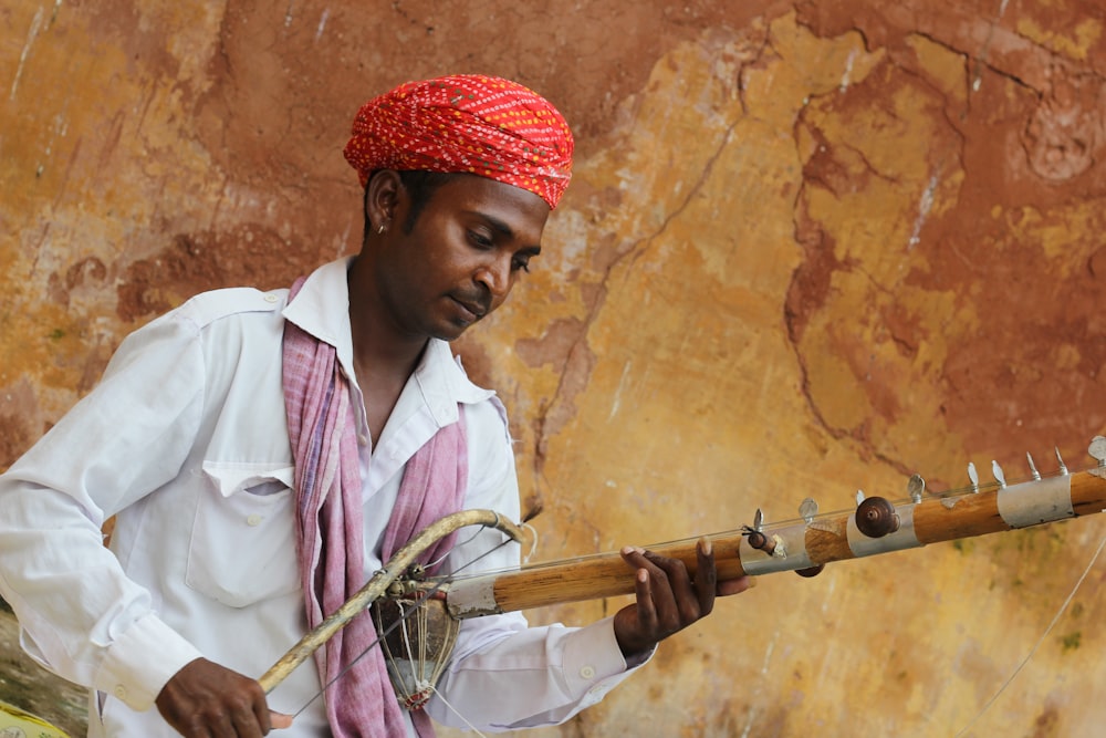 man in red turban playing musical instrument