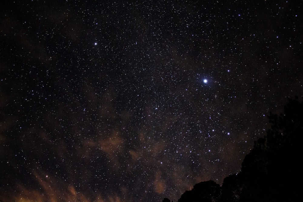 silhouette of mountains and view of stars