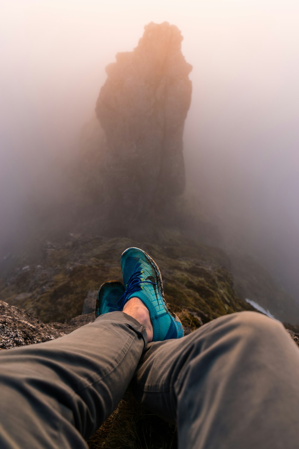 Persona che si siede sul bordo della montagna