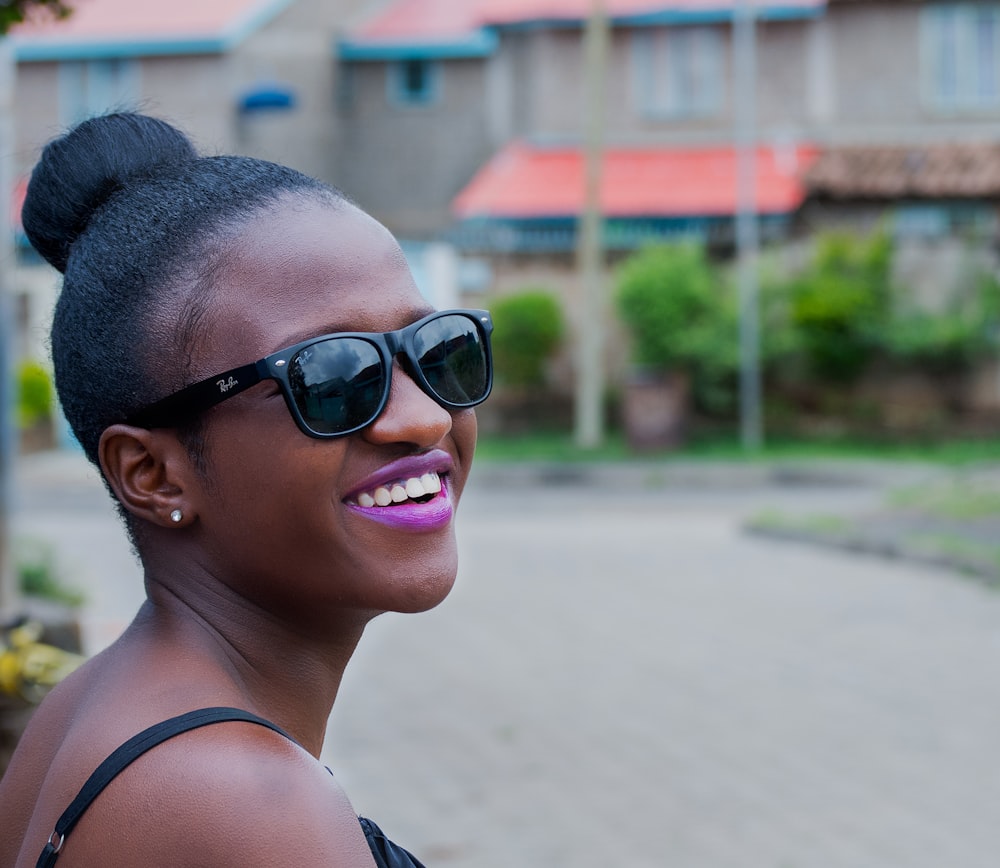 Foto mujer con gafas de sol negras estilo Ray-Ban Wayfarer sonriendo –  Imagen Gafas de sol gratis en Unsplash