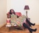 women sitting on sofa chair beside table