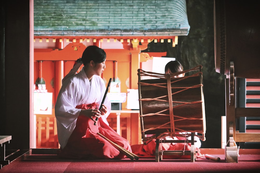 woman playing bamboo wind instrument in front of percussion instrument