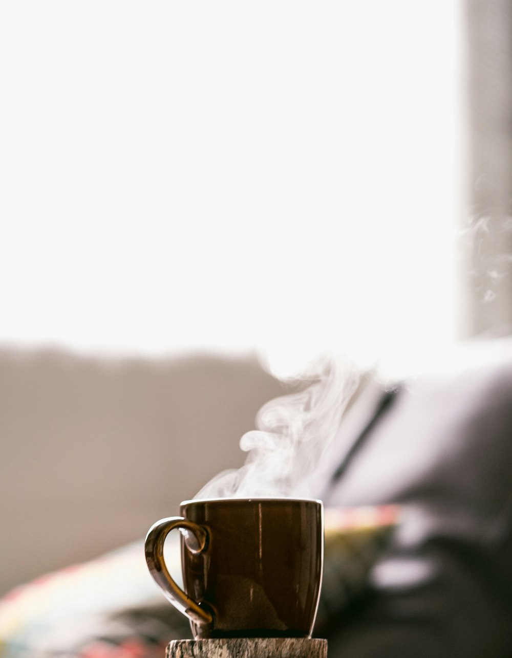 접시가 있는 머그잔에 뜨거운 커피의 얕은 초점 사진