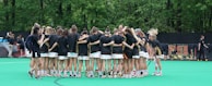 Energetic pre-game huddle of a softball team sporting coordinated custom jerseys and pants.