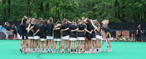 Young female athletes huddled together before a water polo match, showing focus and unity.
