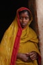 woman leaning on brown bricked wall