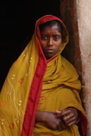 woman leaning on brown bricked wall