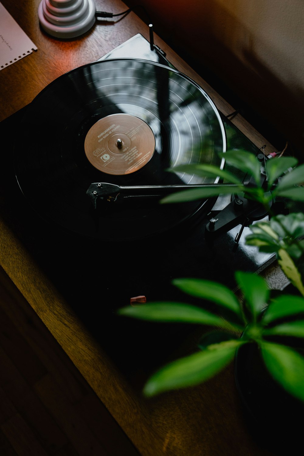 Tocadiscos negro sobre mesa de madera marrón