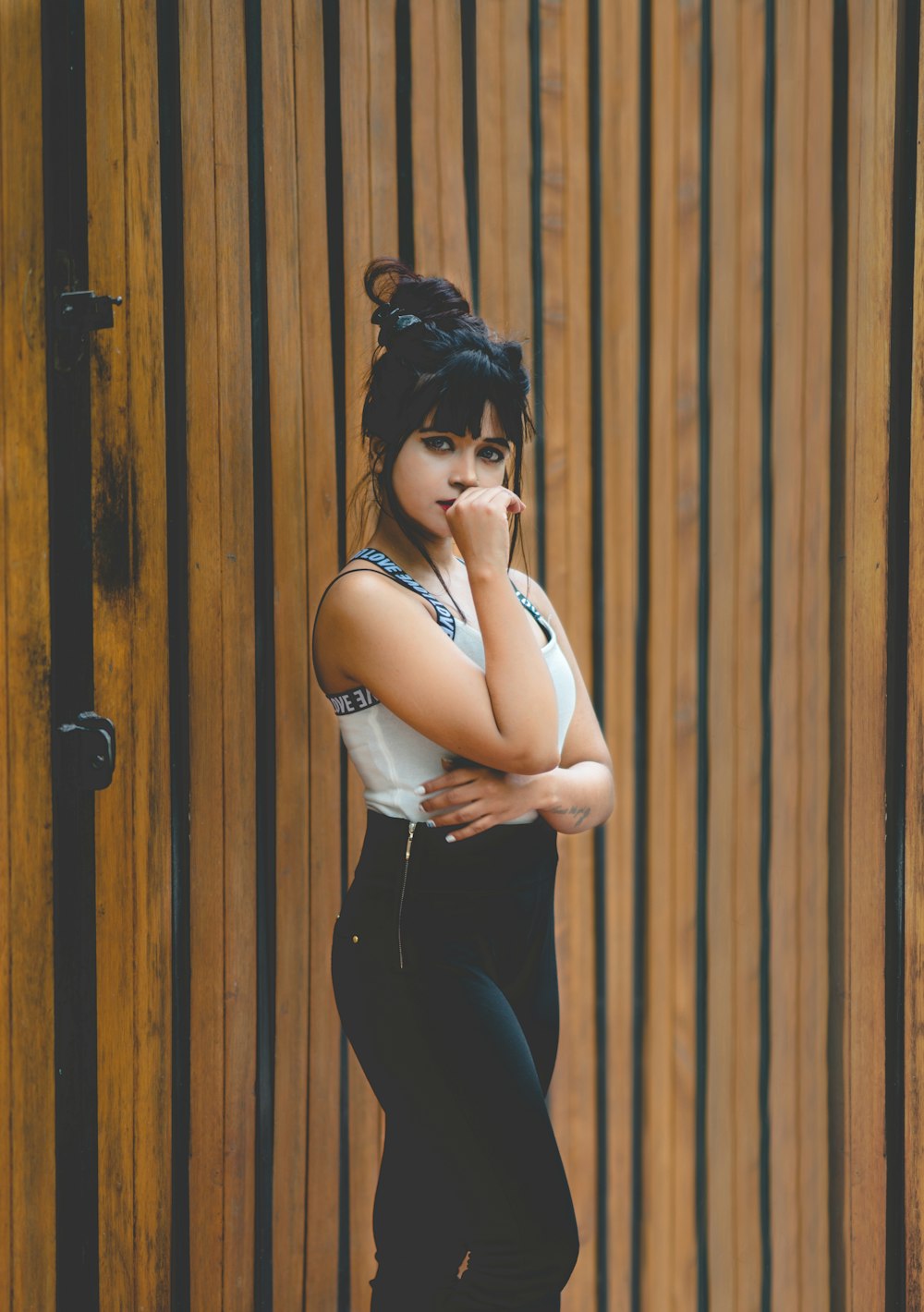 woman standing near brown wooden wall at daytime