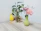 An elegant floral arrangement displayed on a minimalist wooden table in a softly lit room.