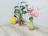 An elegant floral arrangement displayed on a minimalist wooden table in a softly lit room.