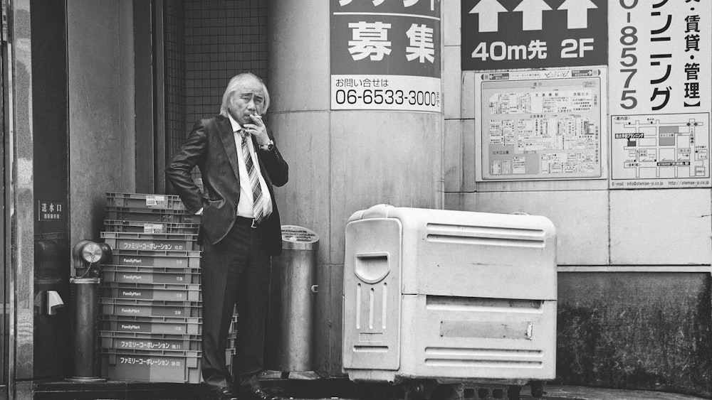 grayscale photo of man smoking cigarette