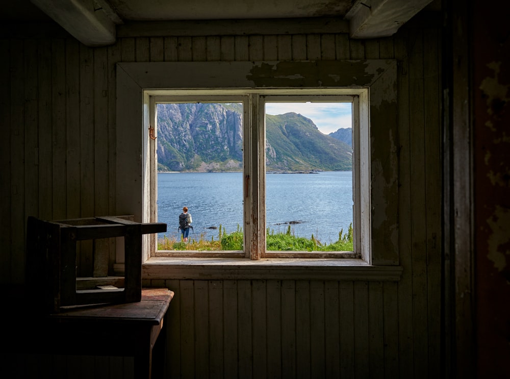 pessoa em pé perto da vista da janela do mar