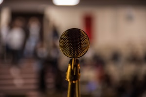 selective focus photography of brass-colored microphone