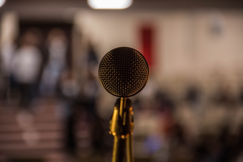 selective focus photography of brass-colored microphone