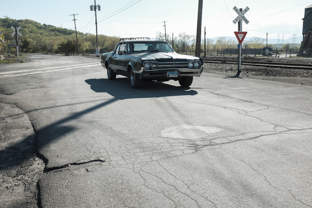 black sedan on gray asphalt road during daytime