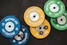 three pairs of assorted-color Rogue bumper plates