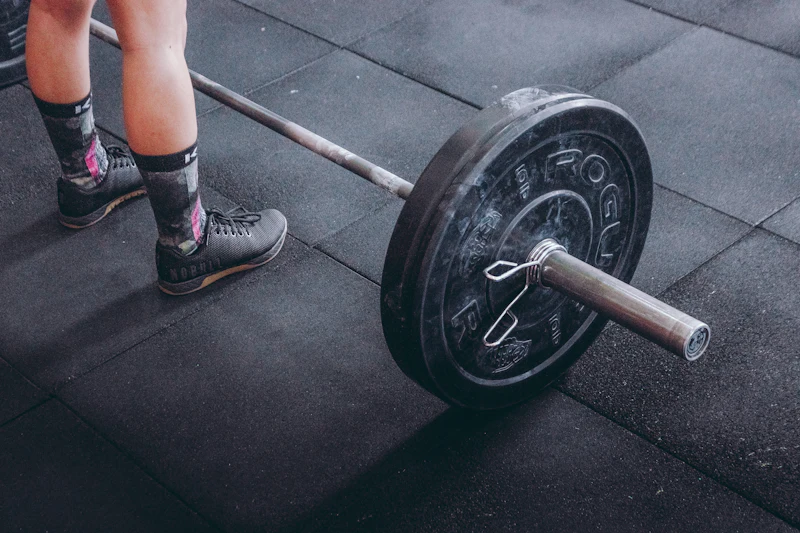 A loaded barbell resting on a gym floor