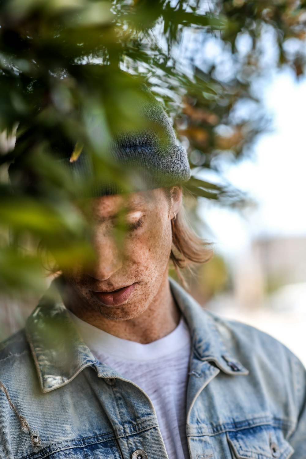 man standing surrounded by leaves