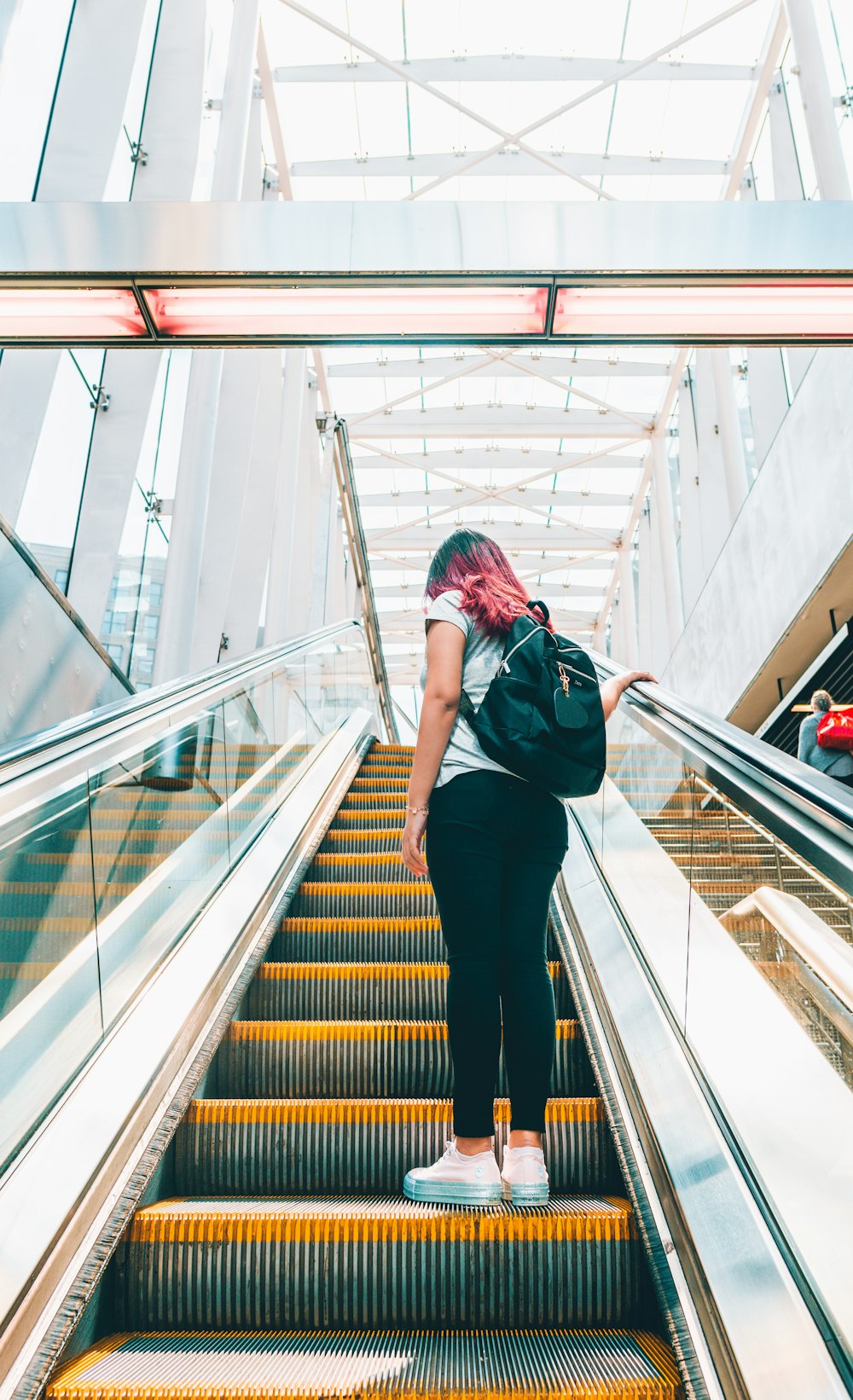 woman standing on escalator