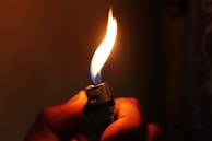 A glowing MK lighter flame illuminating a cozy evening setting outdoors.