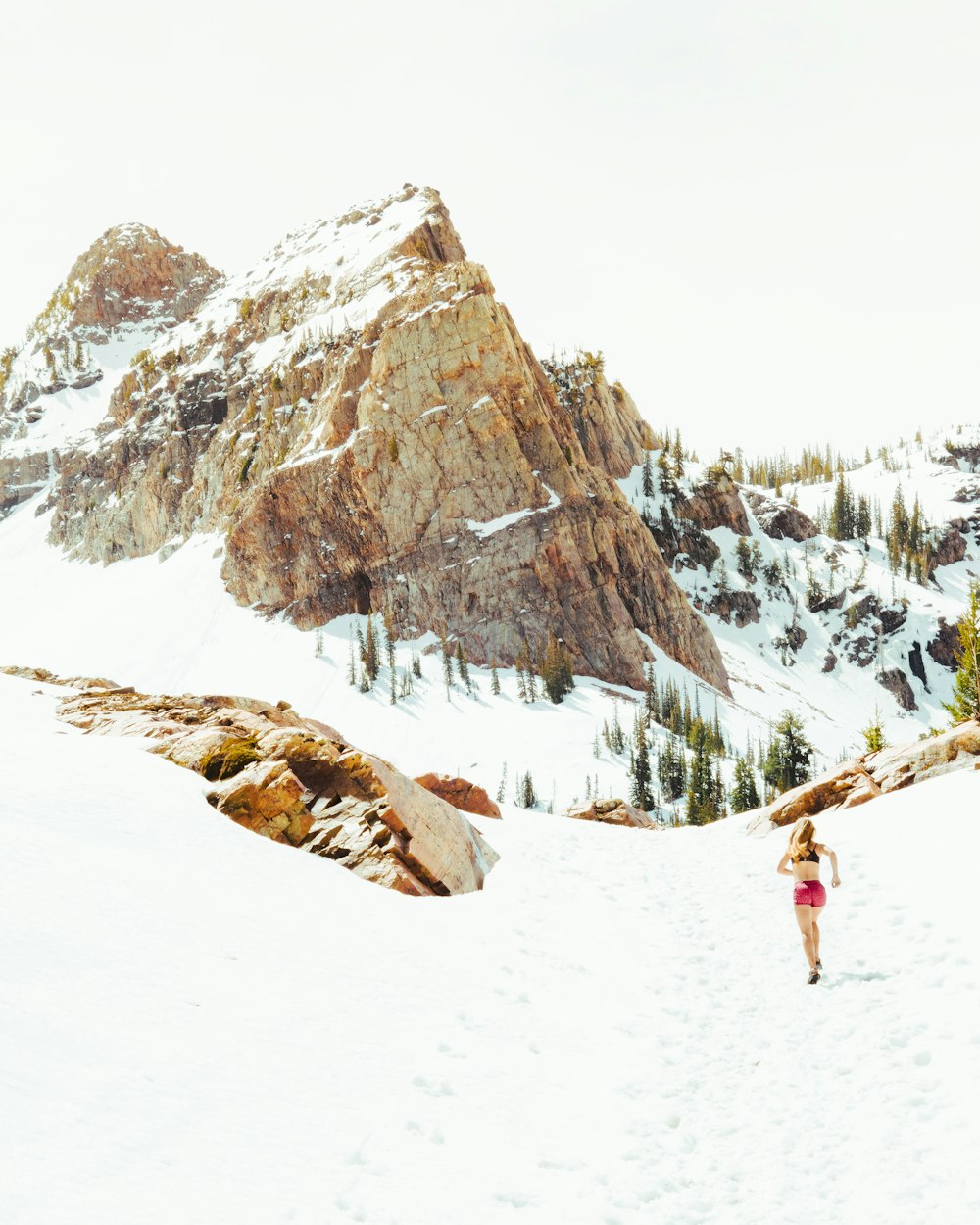 분홍색 반바지를 입은 여자가 산을 달리고 있습니다.