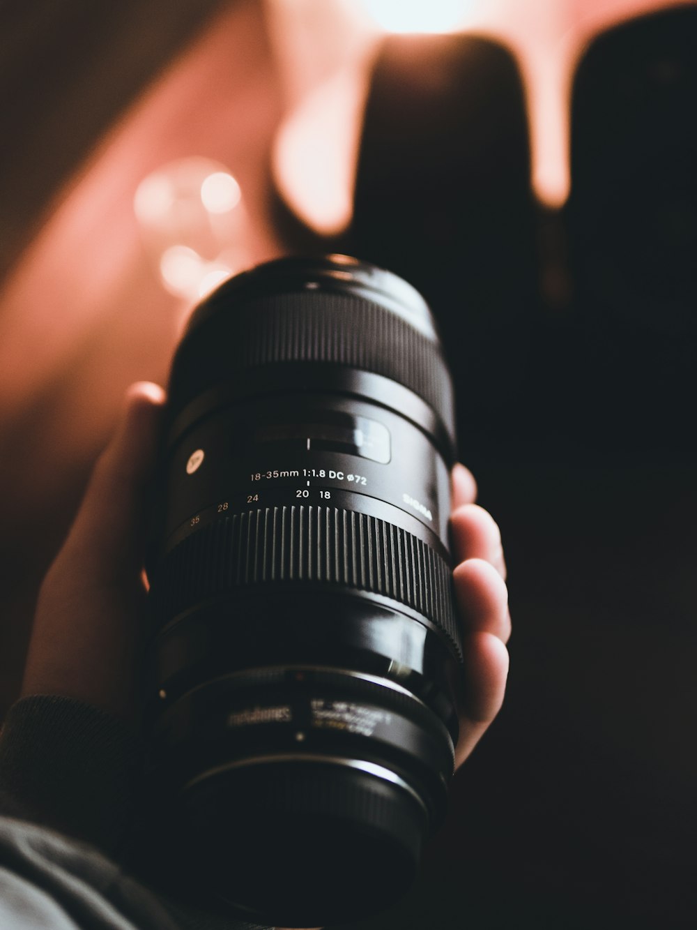 person holding black camera lens