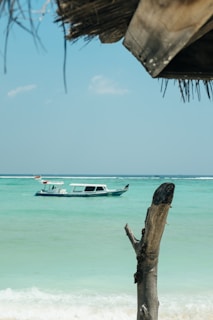 A peaceful boat floating on the turquoise waters of a tropical island lagoon.