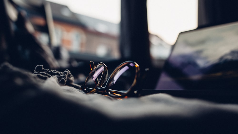 shallow focus photography of black sunglasses with brown frames