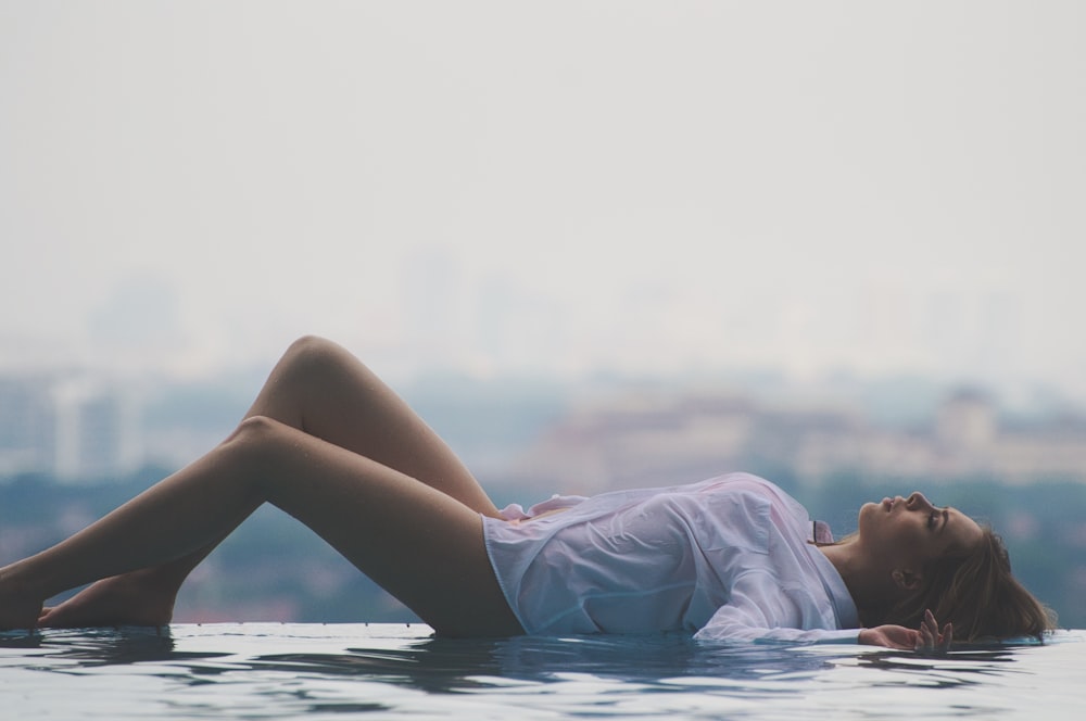 woman lying on pool during daytime
