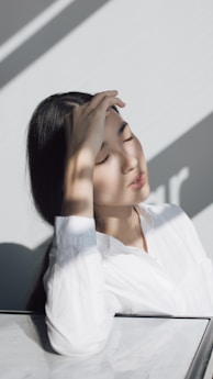 woman leaning on white table