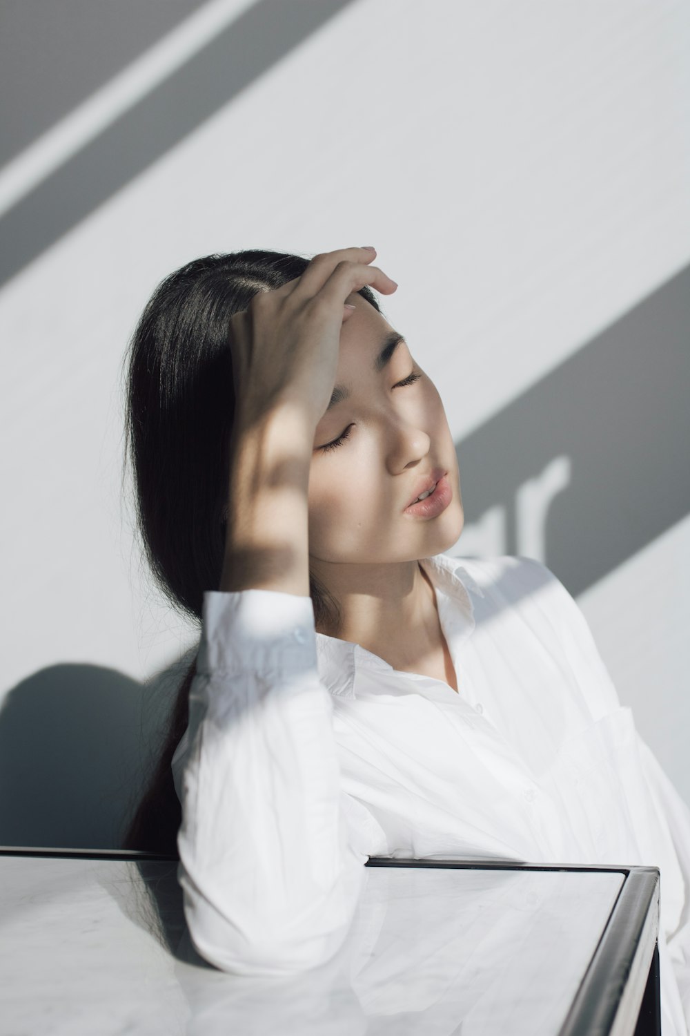 woman leaning on white table