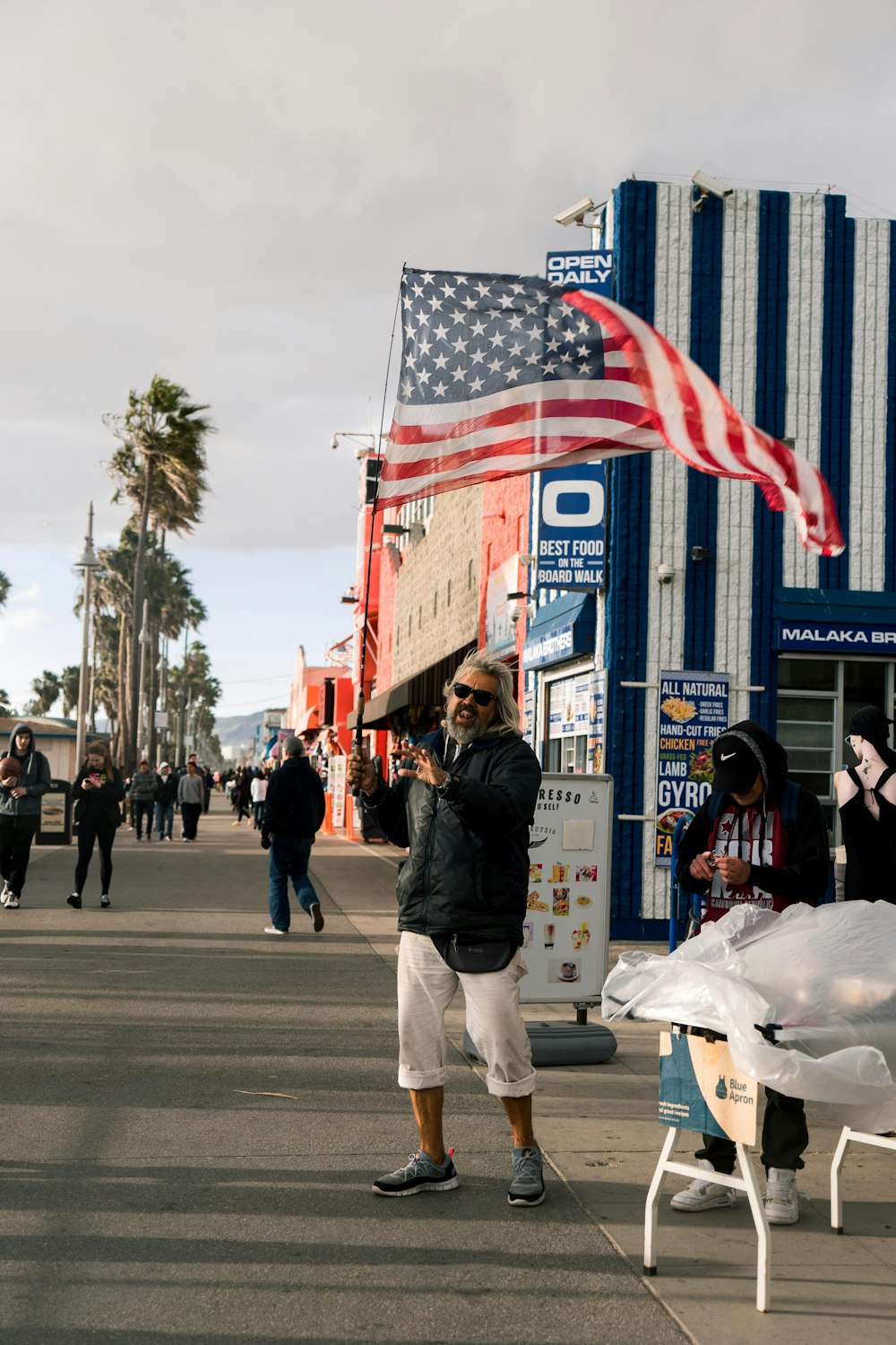 man standing near building and flag of America