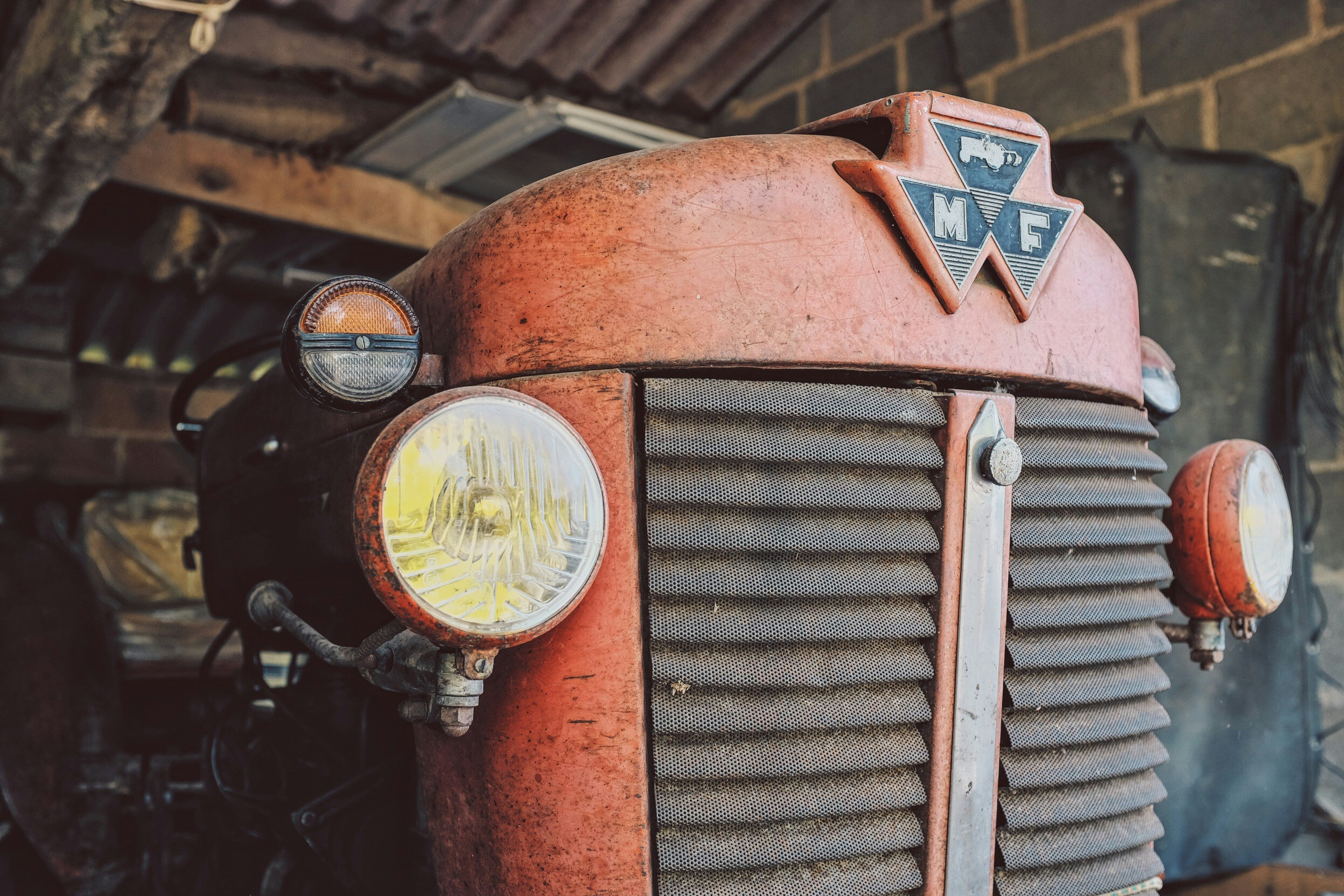 red farm tractor parked at the garage