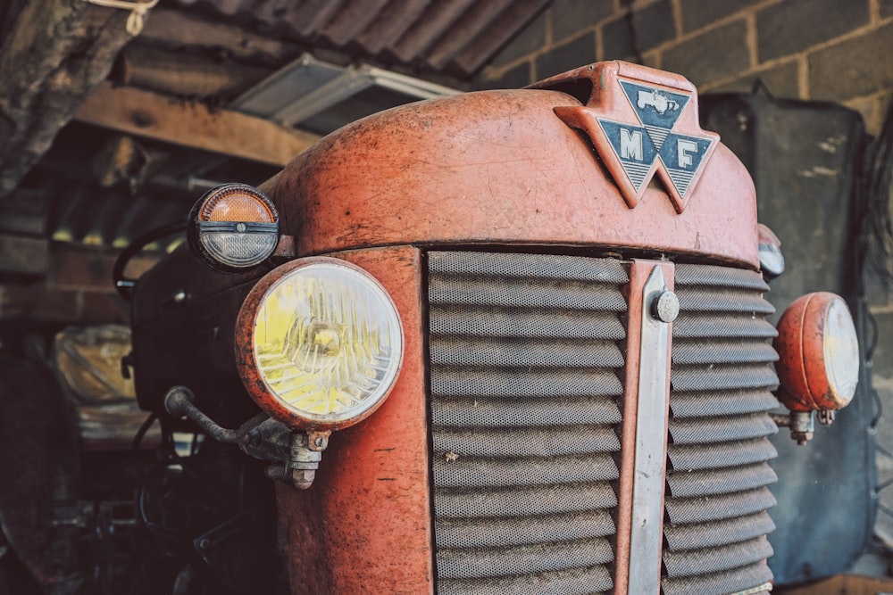 red farm tractor parked at the garage