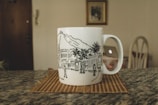 A stylish travel mug resting on a city skyline backdrop.