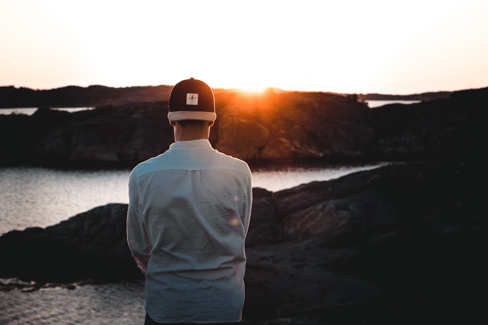 man wearing cap backwards facing the sea