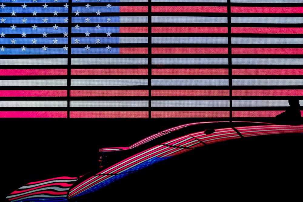 two cars in front of American flag