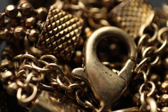 Close-up of a detailed gold chain model with intricate links shining under soft light.