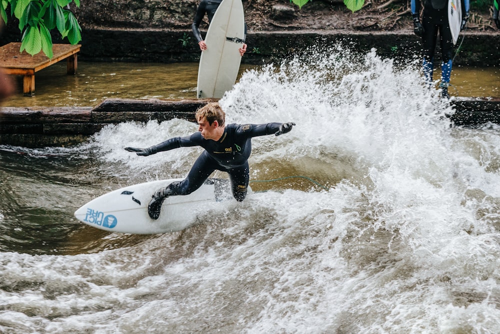 Mann fährt Surfbrett und macht Tricks